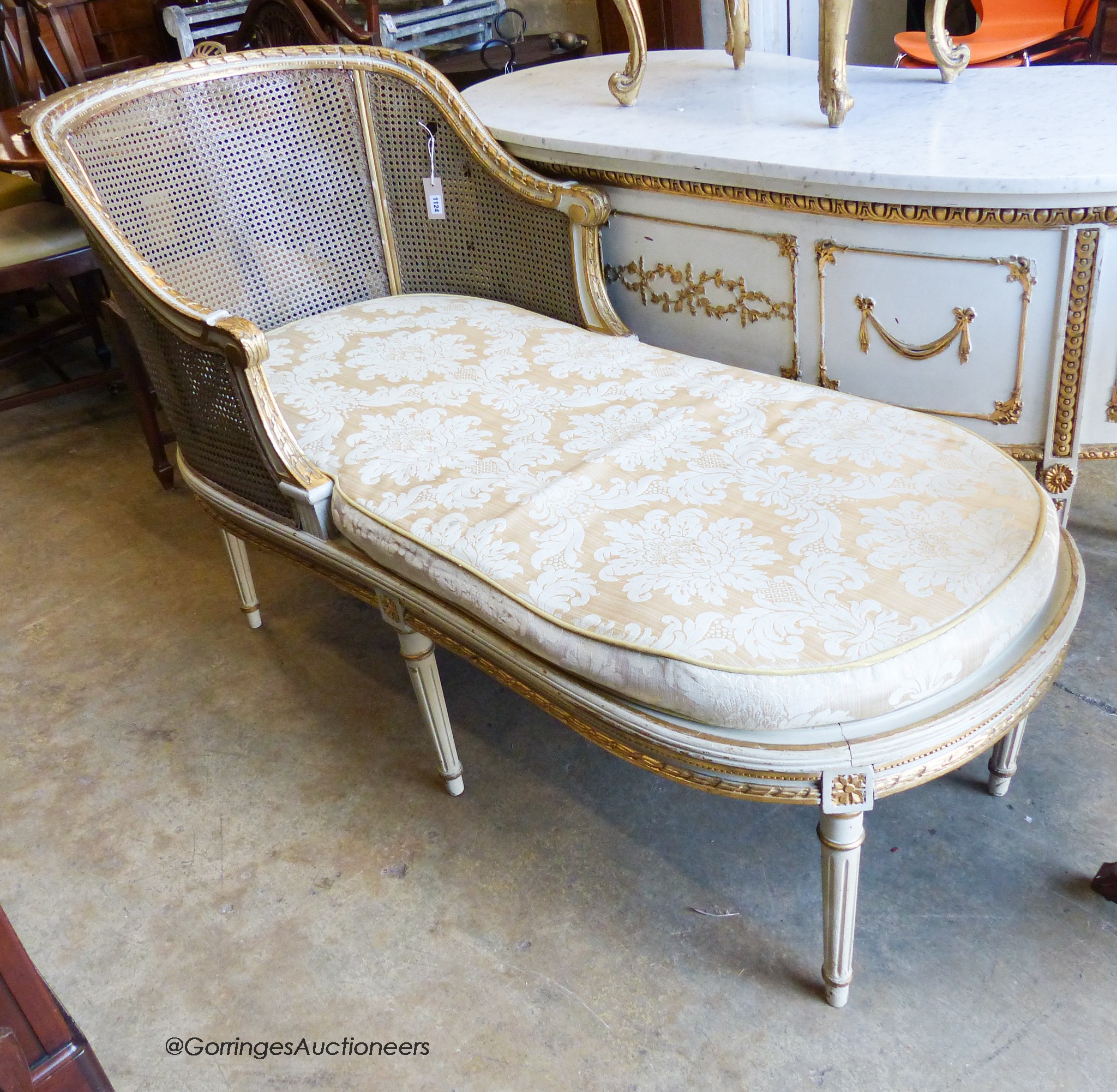 A Louis XVI style painted, giltwood and caned daybed (faults), length 152cm, width 66cm, height 93cm